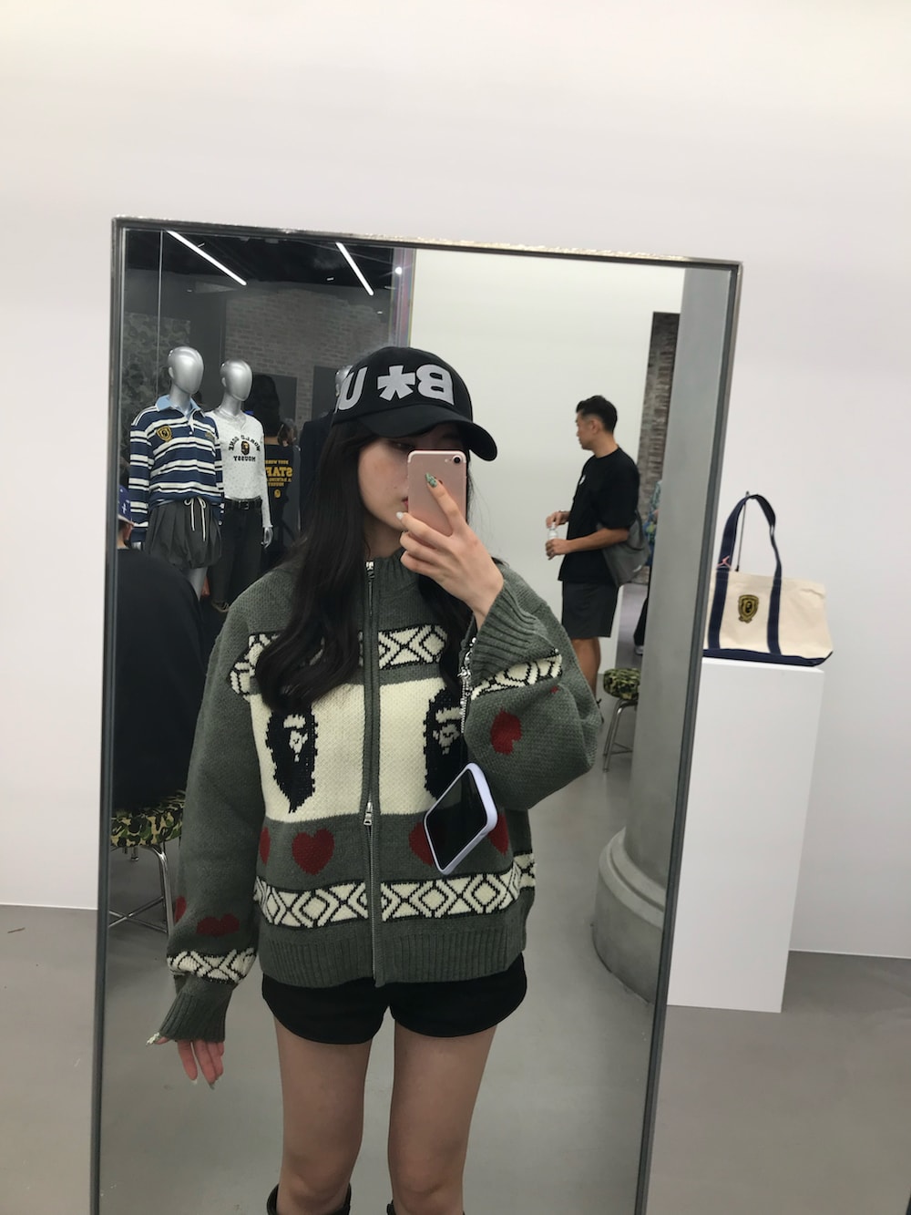 グレー系のカーディガン/ボレロ、ブラック系のブーツ、ブラック系のキャップを着用したレディースの秋コーディネートの3枚目の写真