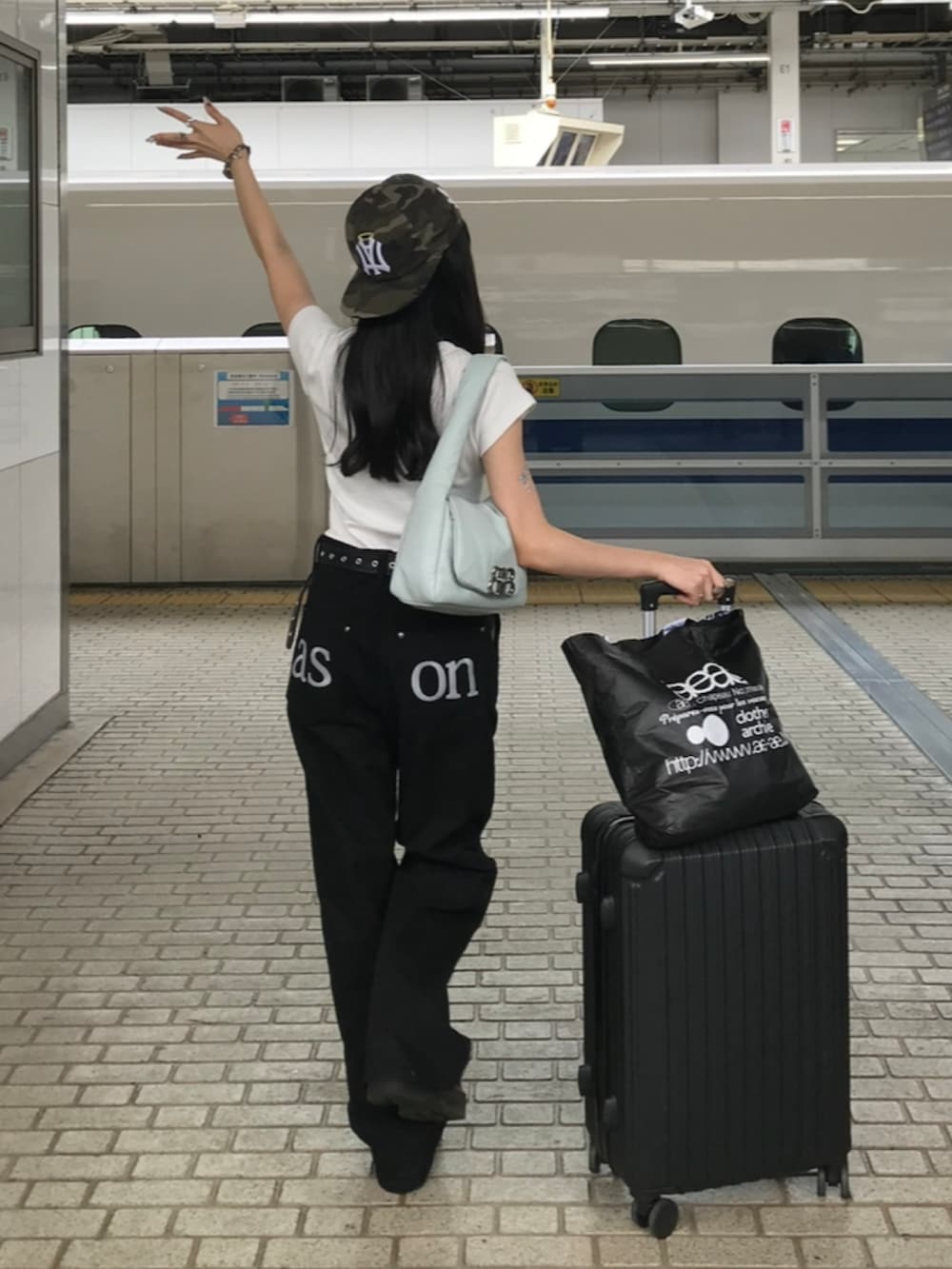 ホワイト系のTシャツ/カットソー、ブラック系のパンツ、ブラック系のブーツを着用したレディースの夏コーディネートの2枚目の写真