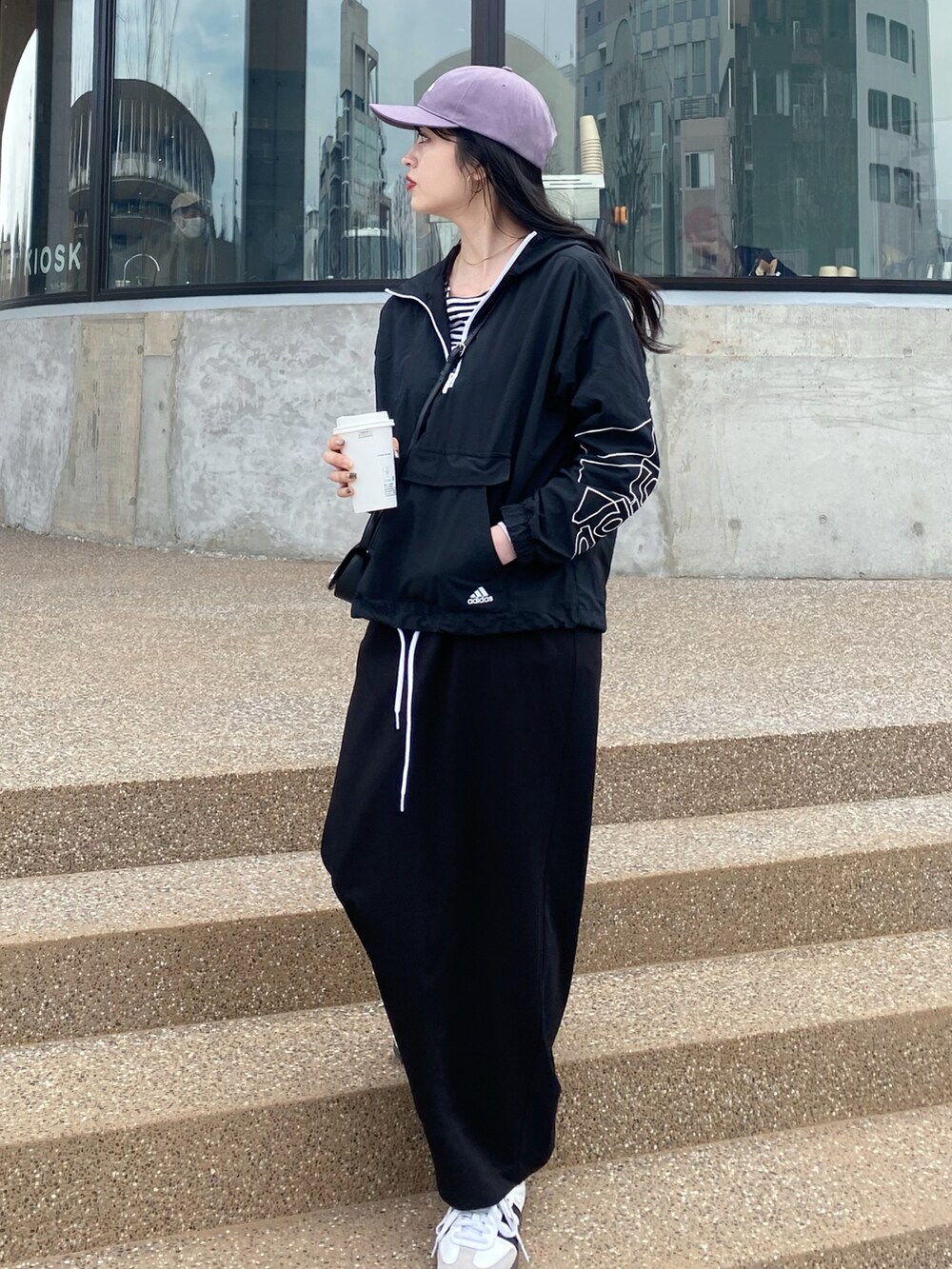 ブラック系のスニーカー、ブラック系のトップス、ブラック系のショルダーバッグを着用したレディースの春コーディネートの2枚目の写真