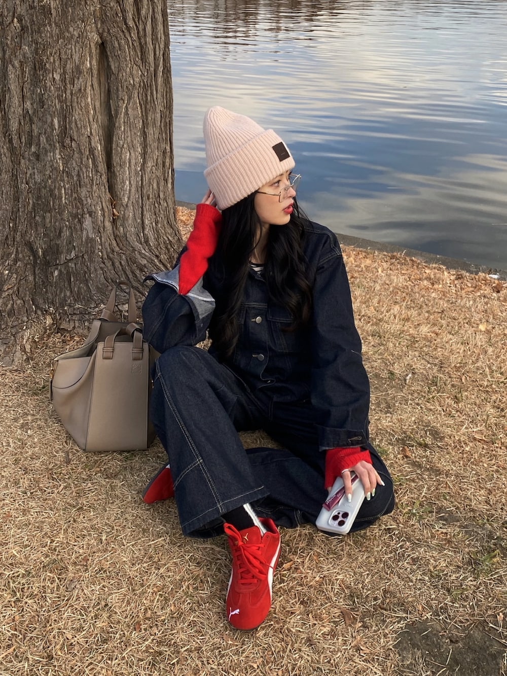 ベージュ系のハンドバッグ、レッド系のスニーカーを着用したレディースの秋コーディネートの2枚目の写真