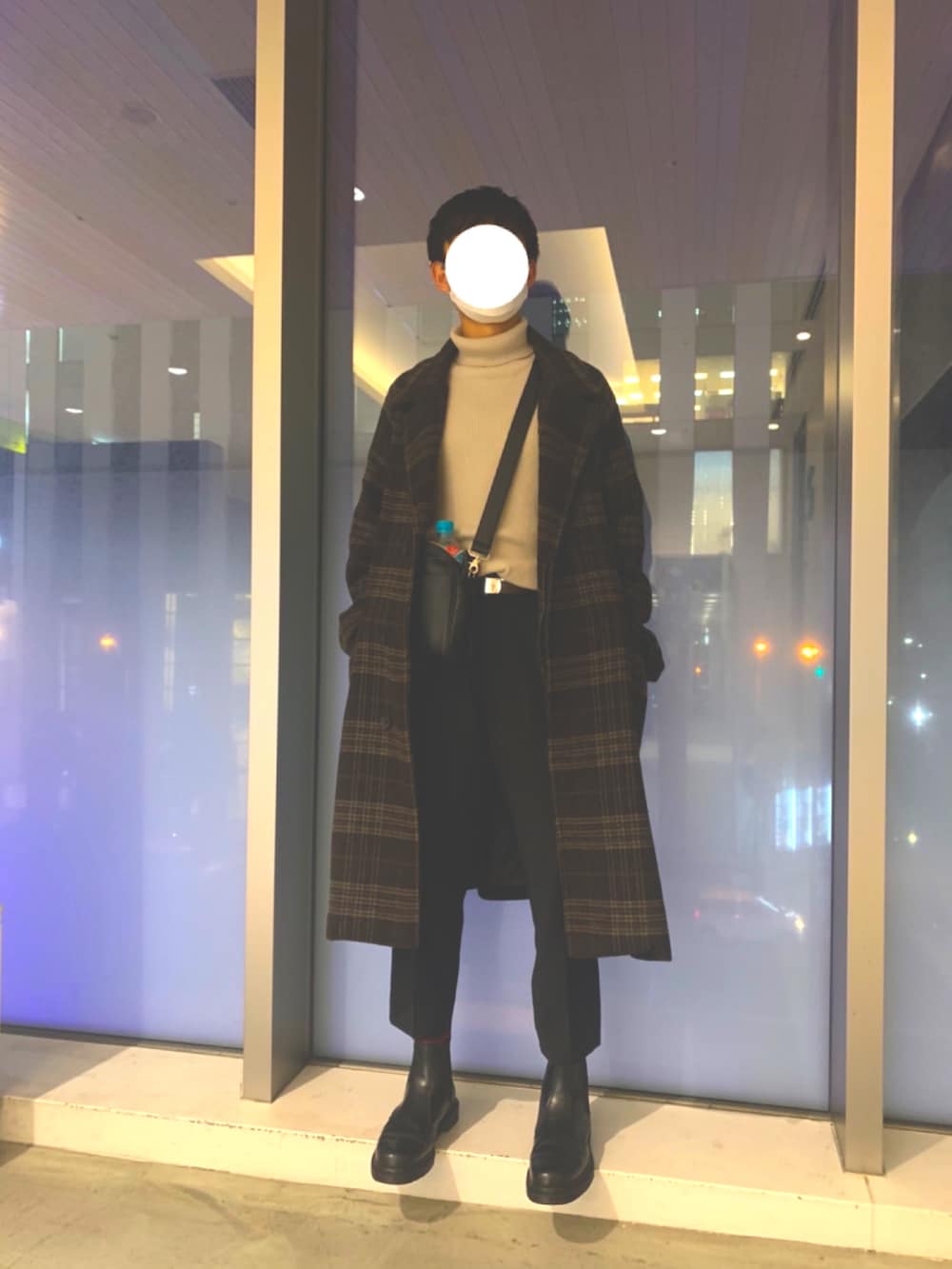 ベージュ系のニット/セーター、ブラック系のブーツ、ブラック系のスラックスを着用したメンズの冬コーディネートの2枚目の写真