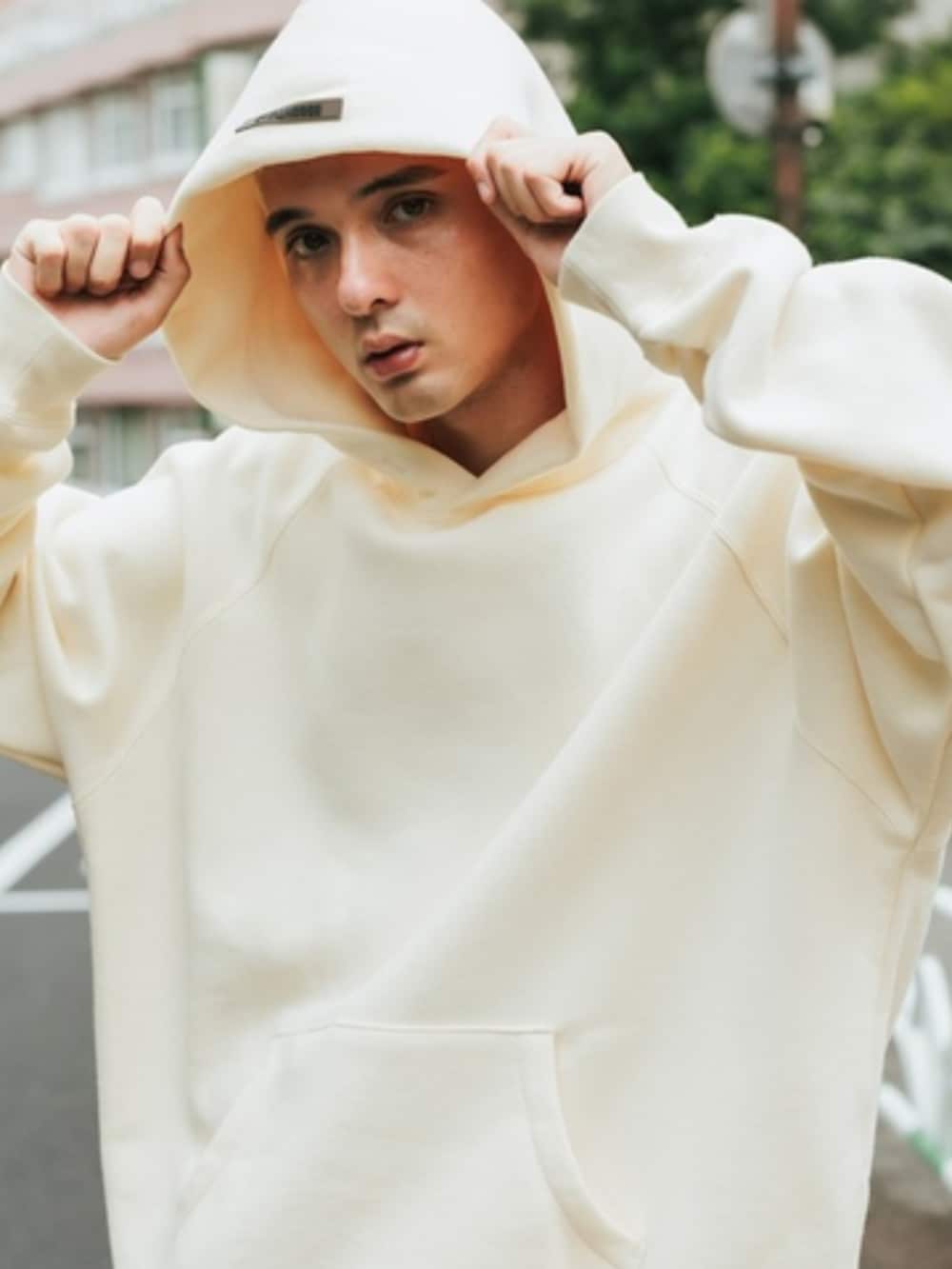 ベージュ系のパーカーを着用したメンズの春コーディネートの3枚目の写真