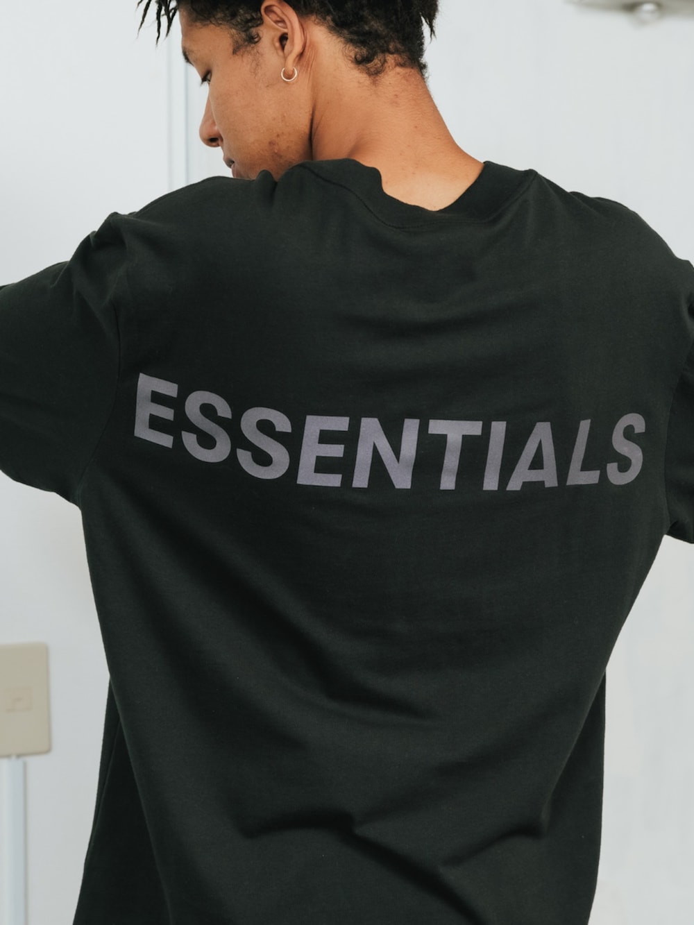 ブラック系のTシャツ/カットソー、グリーン系のチノパンツを着用したメンズの春コーディネートの3枚目の写真