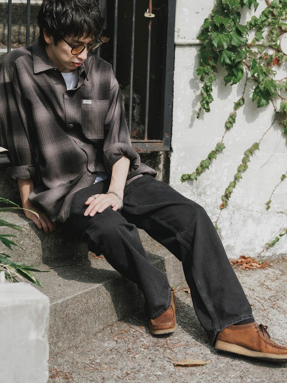 ブラック系のデニムパンツを着用したレディースの春コーディネートの2枚目の写真