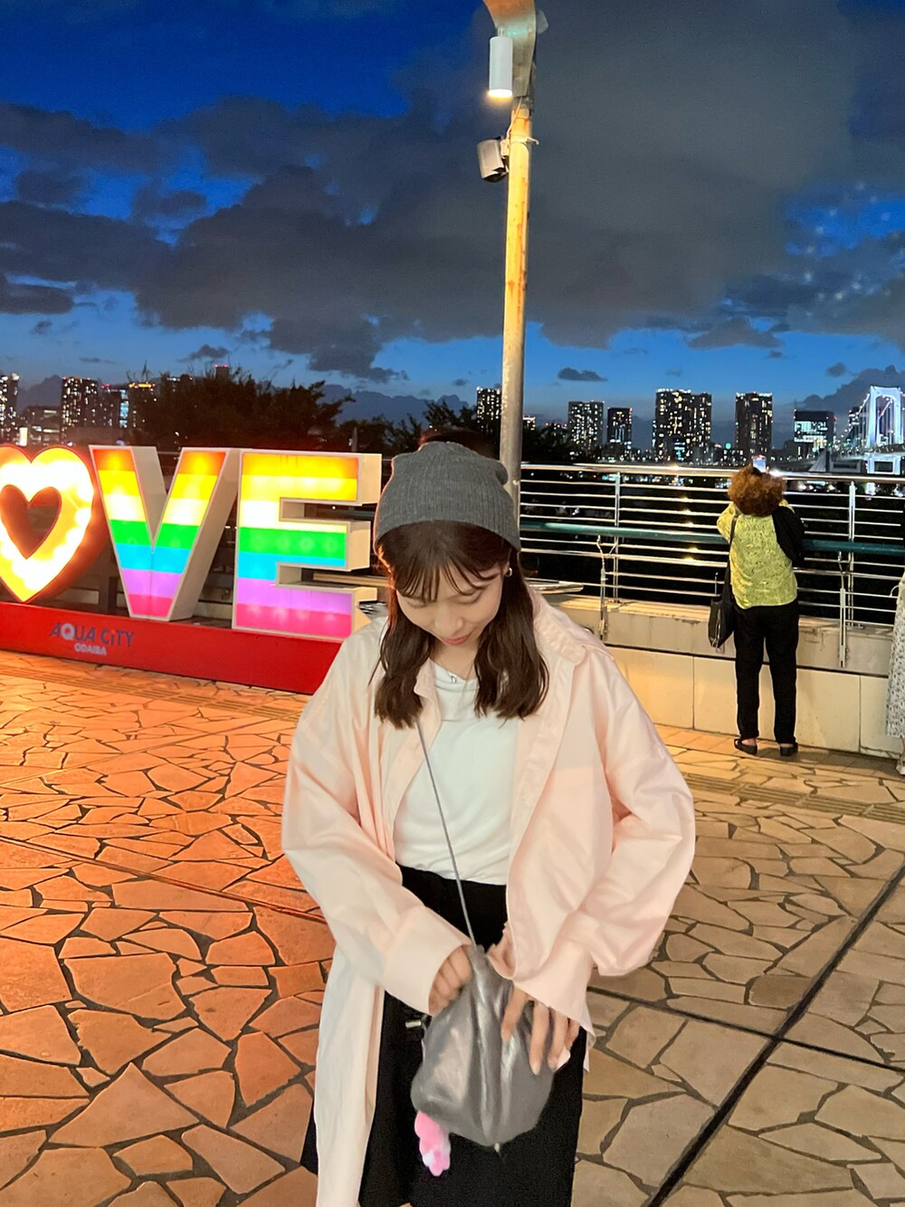 ピンク系のシャツ/ブラウスを着用したレディースの夏コーディネートの2枚目の写真