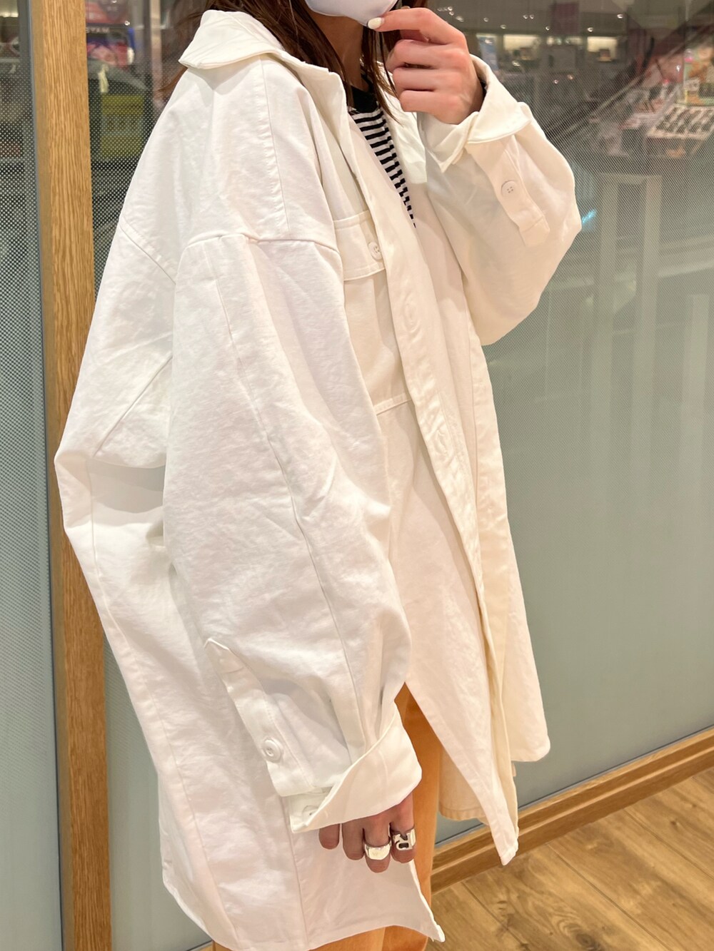 ホワイト系のシャツ/ブラウス、オレンジ系のデニムパンツ、シルバー系のサンダルを着用したレディースの春コーディネートの4枚目の写真