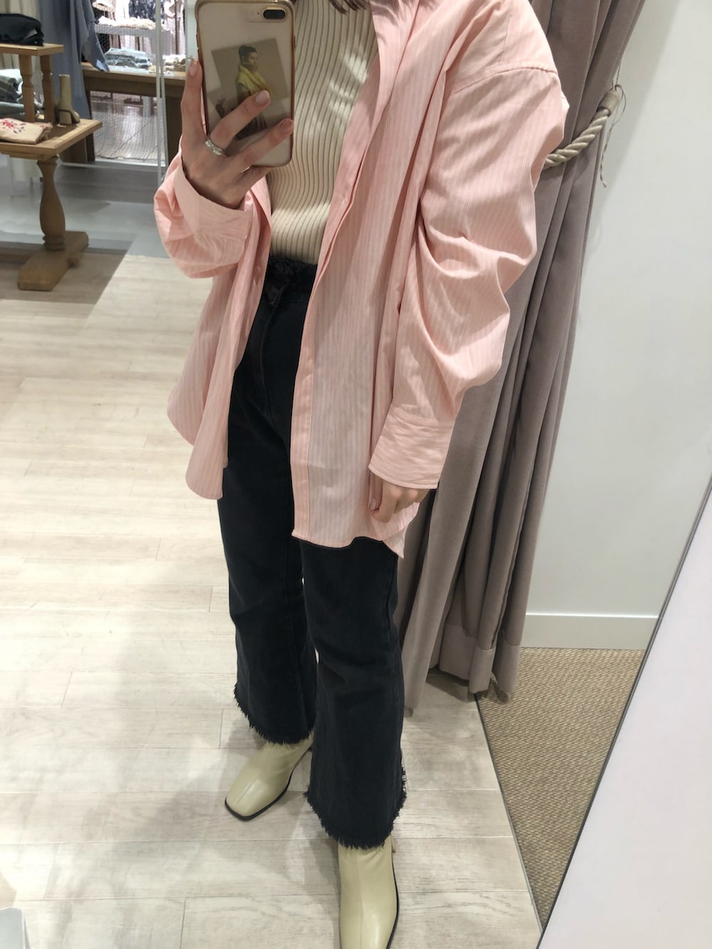 ホワイト系のニット/セーター、ブルー系のシャツ/ブラウス、ブラック系のデニムパンツを着用したレディースの冬コーディネートの2枚目の写真