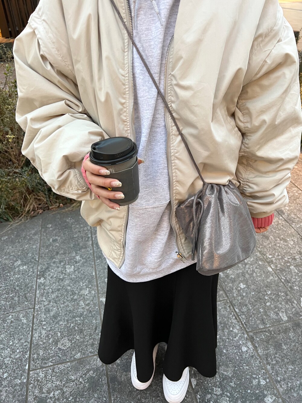グレー系のブルゾン、グレー系のパーカー、ベージュ系のニット/セーターを着用したレディースの冬コーディネートの3枚目の写真