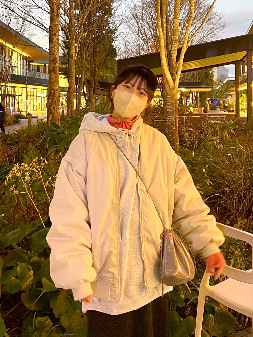 グレー系のブルゾン、グレー系のパーカー、ブラック系のスカートを着用したレディースの冬コーディネートの3枚目の写真