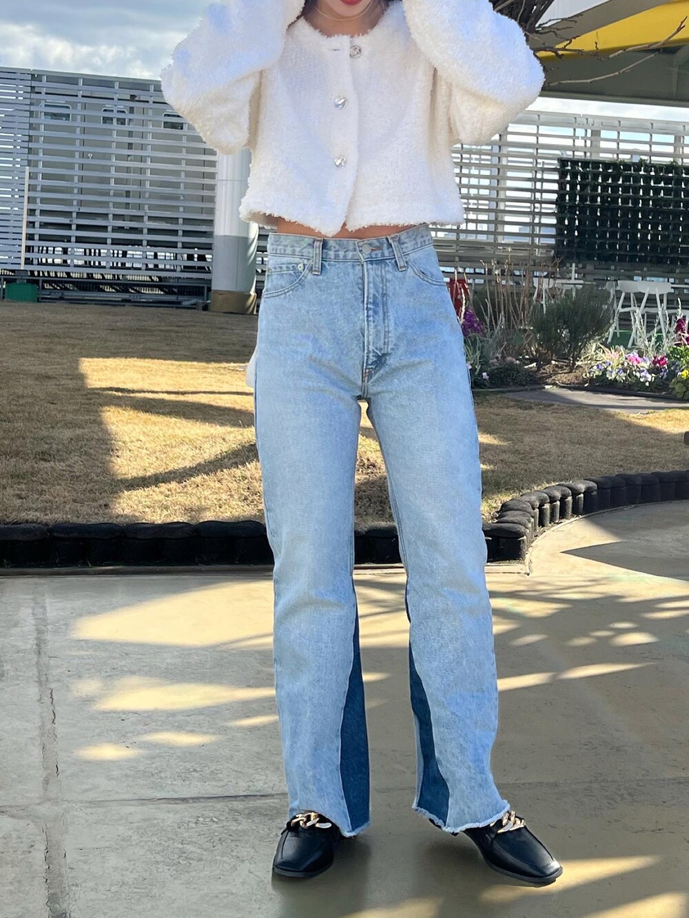 ホワイト系のカーディガン/ボレロ、ブルー系のデニムパンツ、ブラック系のローファーを着用したレディースの冬コーディネートの4枚目の写真