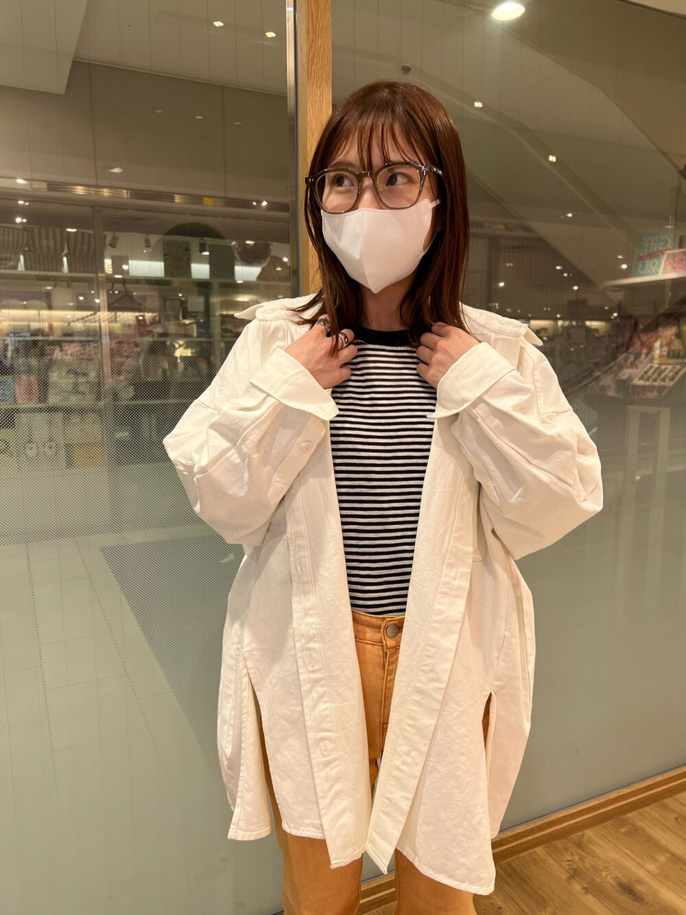 ホワイト系のシャツ/ブラウス、オレンジ系のデニムパンツ、シルバー系のサンダルを着用したレディースの春コーディネートの3枚目の写真