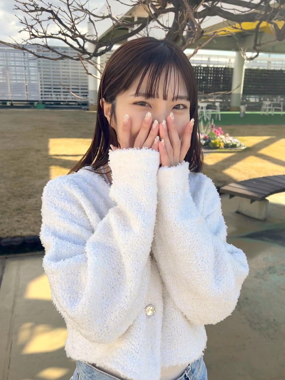 ホワイト系のカーディガン/ボレロ、ブルー系のデニムパンツ、ブラック系のローファーを着用したレディースの冬コーディネートの3枚目の写真