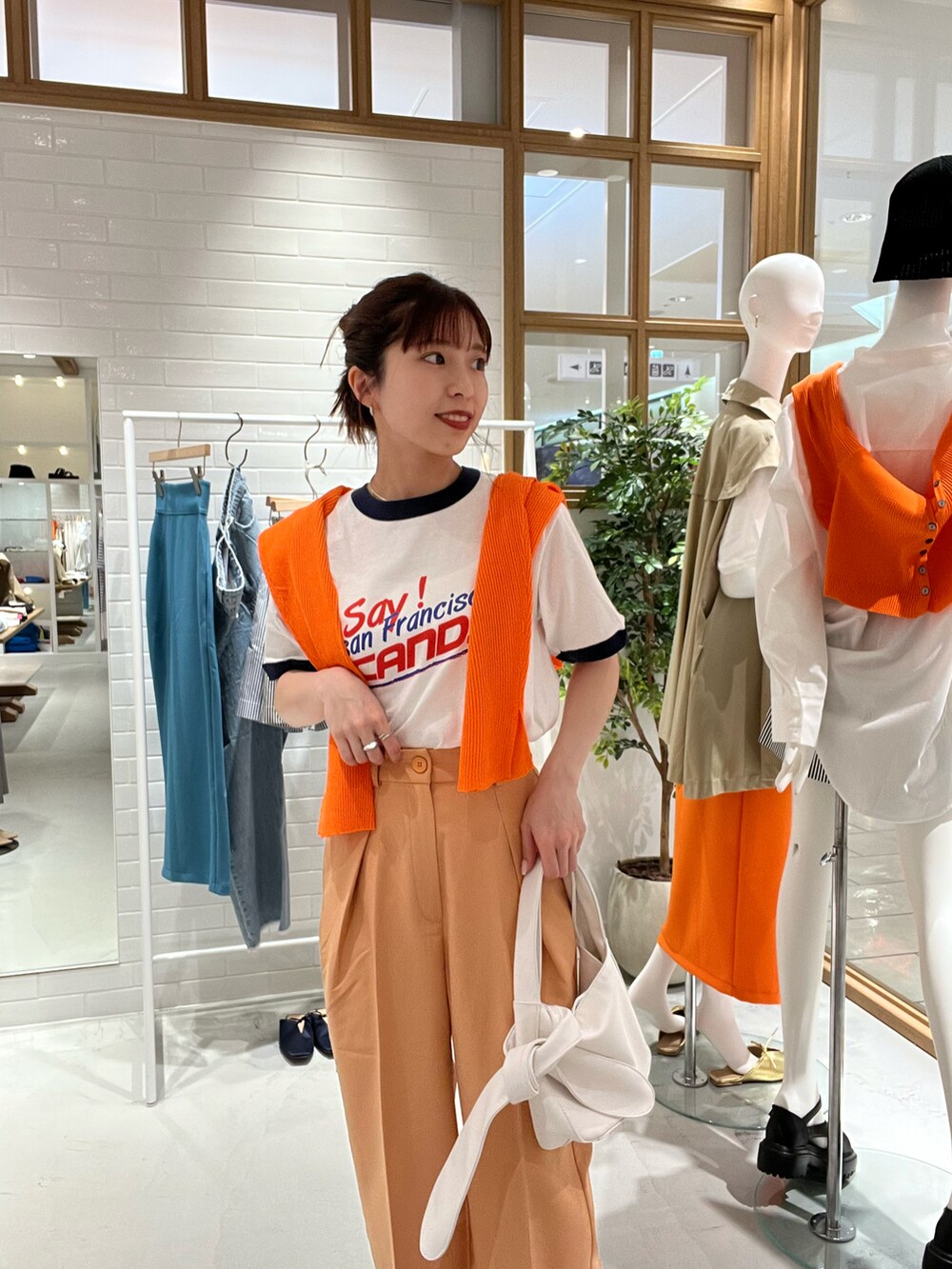 ホワイト系のTシャツ/カットソー、オレンジ系のカーディガン/ボレロ、オレンジ系のその他パンツを着用したレディースの春コーディネートの2枚目の写真