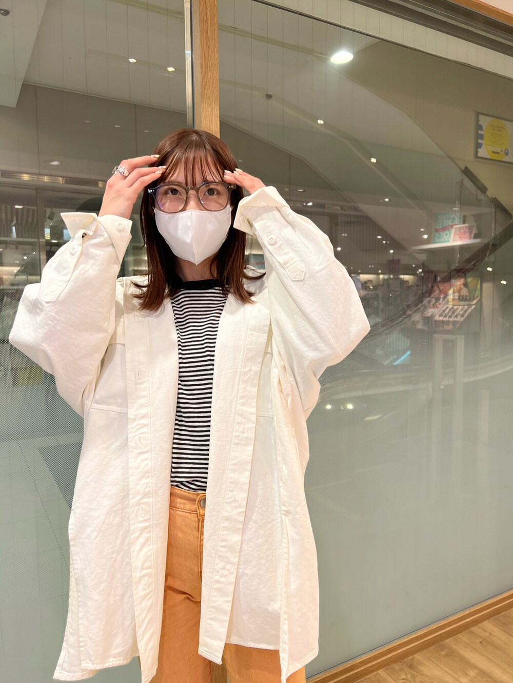 ホワイト系のシャツ/ブラウス、オレンジ系のデニムパンツ、シルバー系のサンダルを着用したレディースの春コーディネートの2枚目の写真