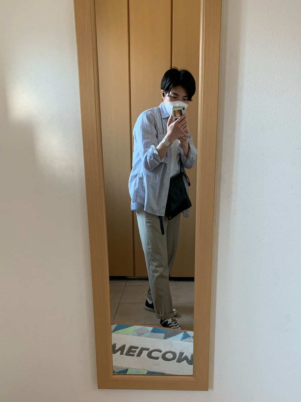 ホワイト系のTシャツ/カットソー、ブルー系のシャツ/ブラウス、ベージュ系のスラックスを着用したメンズの春コーディネートの2枚目の写真