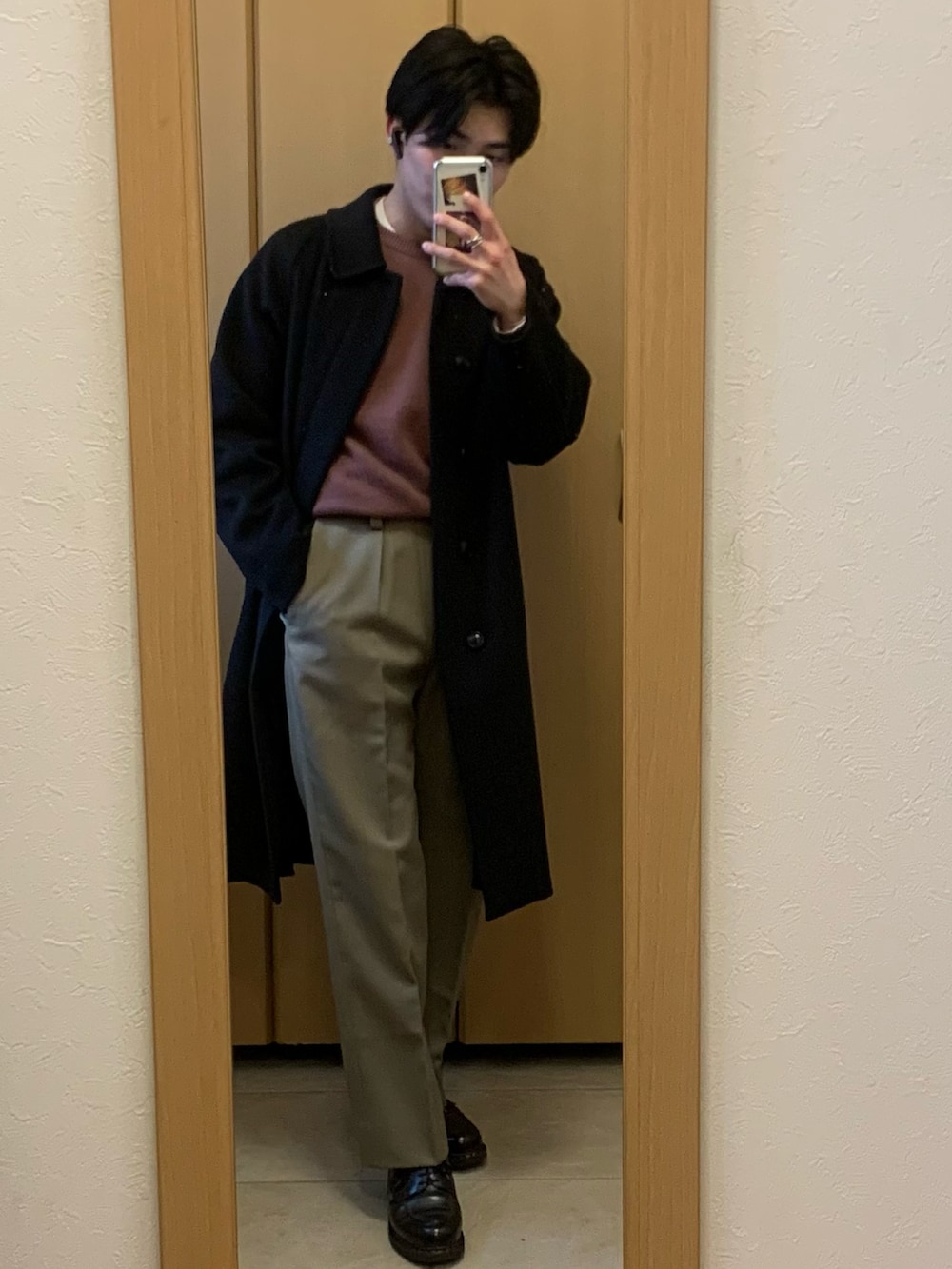 ホワイト系のTシャツ/カットソー、ブラウン系のステンカラーコート、ベージュ系のスラックスを着用したメンズの冬コーディネートの2枚目の写真