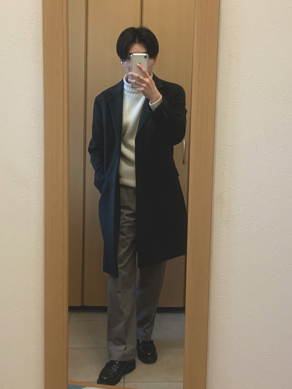 ブラウン系のチェスターコート、ホワイト系のニット/セーター、ベージュ系のその他パンツを着用したメンズの冬コーディネートの3枚目の写真