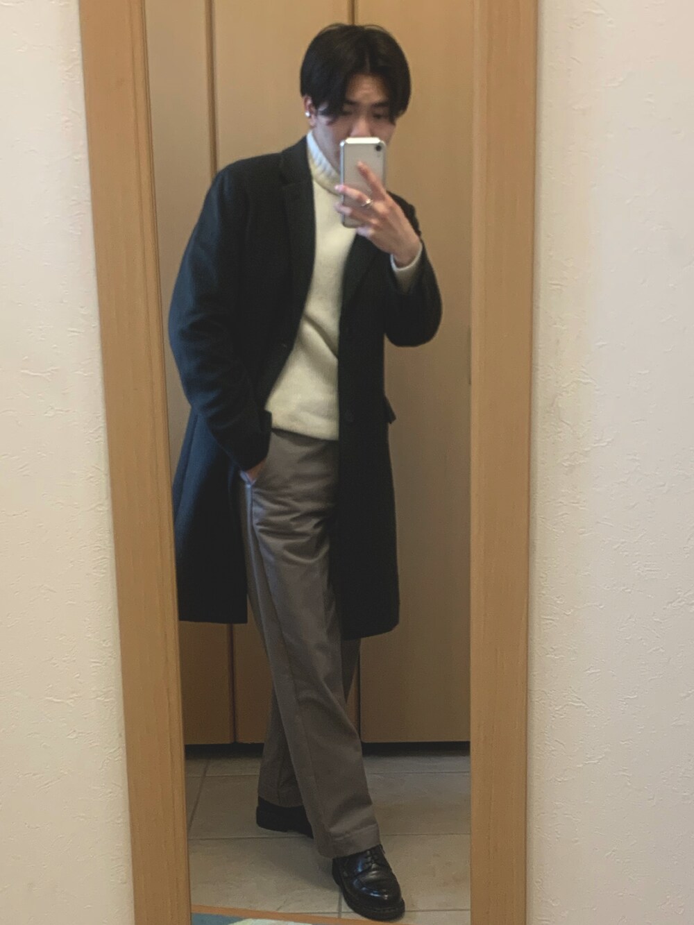 ブラウン系のチェスターコート、ホワイト系のニット/セーター、ベージュ系のその他パンツを着用したメンズの冬コーディネートの2枚目の写真