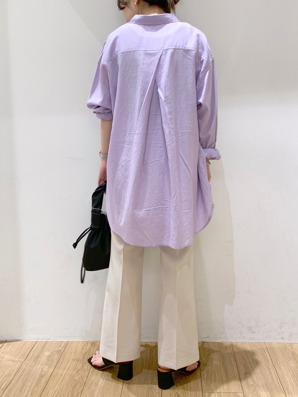 ブラウン系のタンクトップ、パープル系のシャツ/ブラウス、ホワイト系のスラックスを着用したレディースの春コーディネートの2枚目の写真