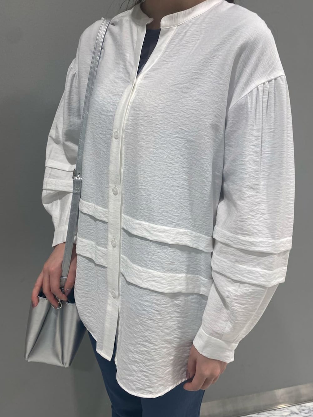 ホワイト系のシャツ/ブラウス、グレー系のその他パンツ、シルバー系のトートバッグを着用したレディースの春コーディネートの2枚目の写真