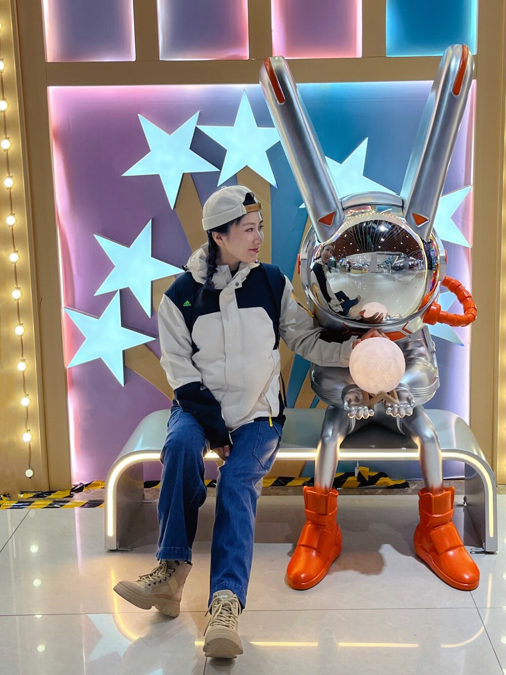 ベージュ系のマウンテンパーカー、ブルー系のデニムパンツを着用したレディースの冬コーディネートの2枚目の写真