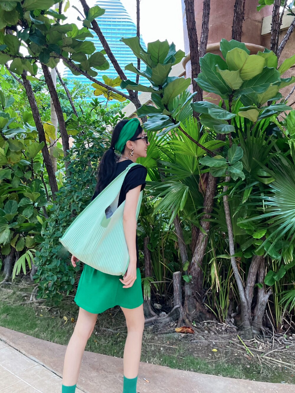 ブラック系のTシャツ/カットソー、グリーン系のスカートを着用したレディースの春コーディネートの2枚目の写真