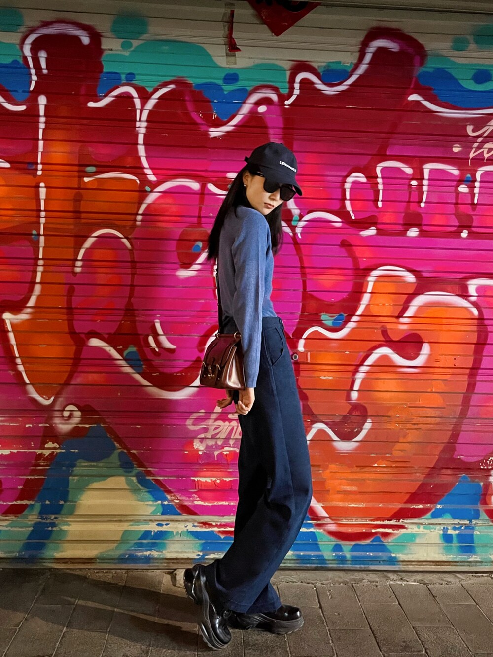 ブルー系のニット/セーター、ブルー系のデニムパンツを着用したレディースの春コーディネートの2枚目の写真