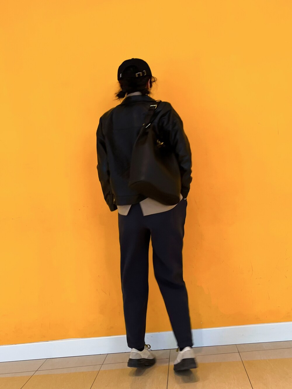 ブラック系のライダースジャケット、ベージュ系のスーツジャケットを着用したレディースの冬コーディネートの2枚目の写真