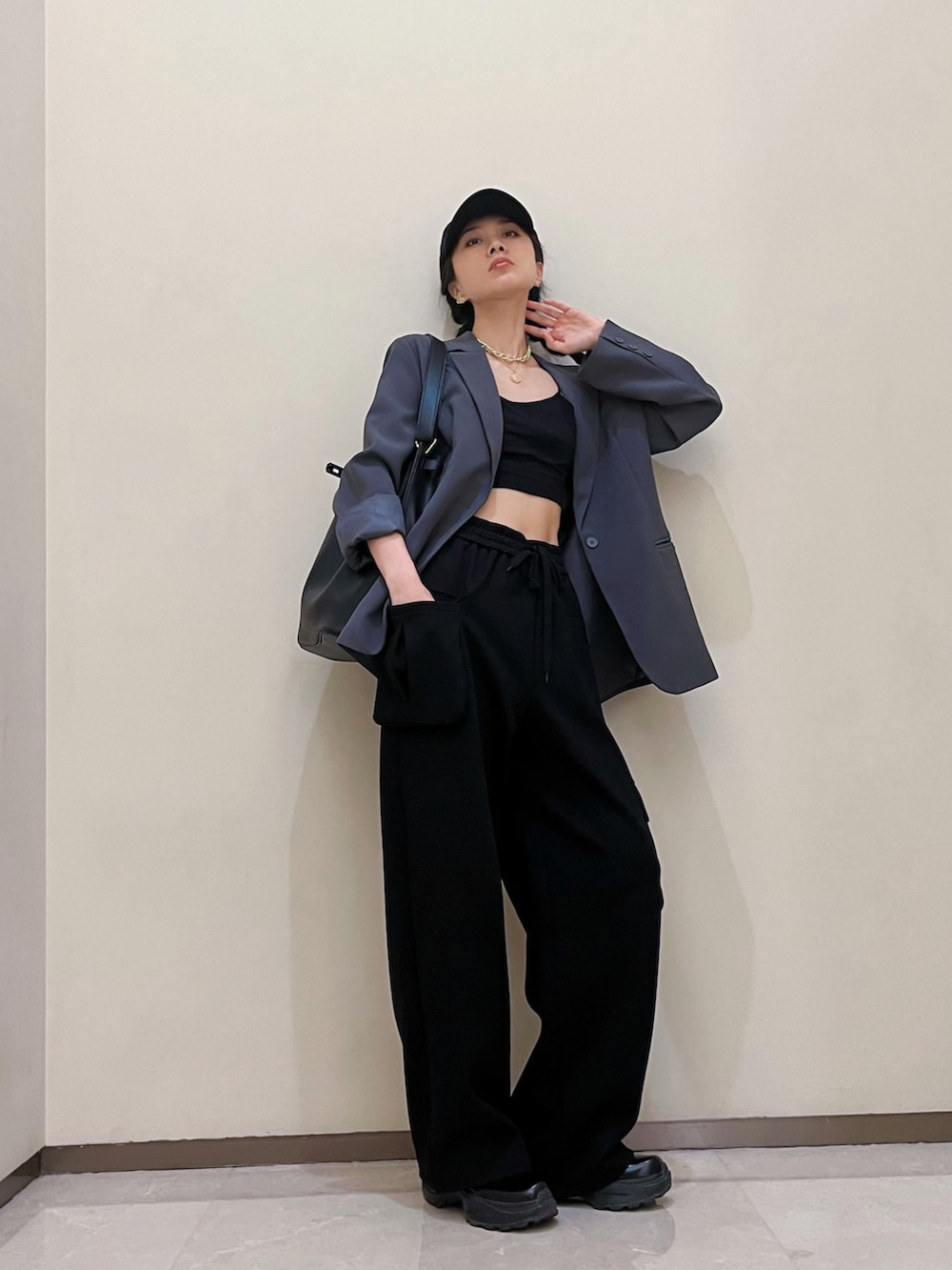 グレー系のテーラードジャケット、ブラック系のチノパンツを着用したレディースの夏コーディネートの2枚目の写真