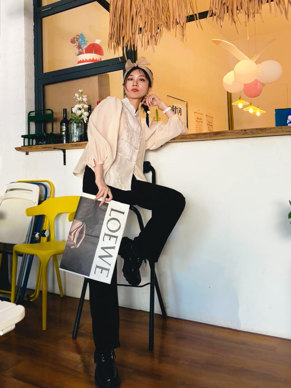 ブラック系のスラックスを着用したレディースの夏コーディネートの2枚目の写真