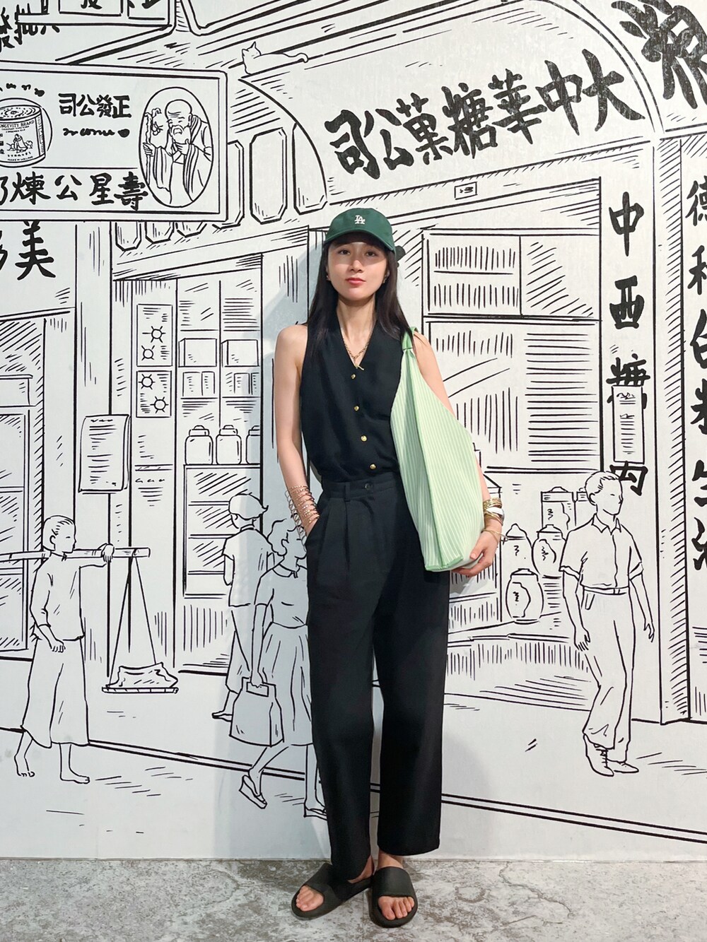 ブラック系のタンクトップ、ブラック系のチノパンツを着用したレディースの夏コーディネートの2枚目の写真