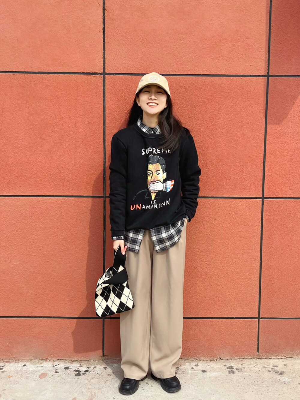 ベージュ系のスラックスを着用したレディースの春コーディネートの2枚目の写真