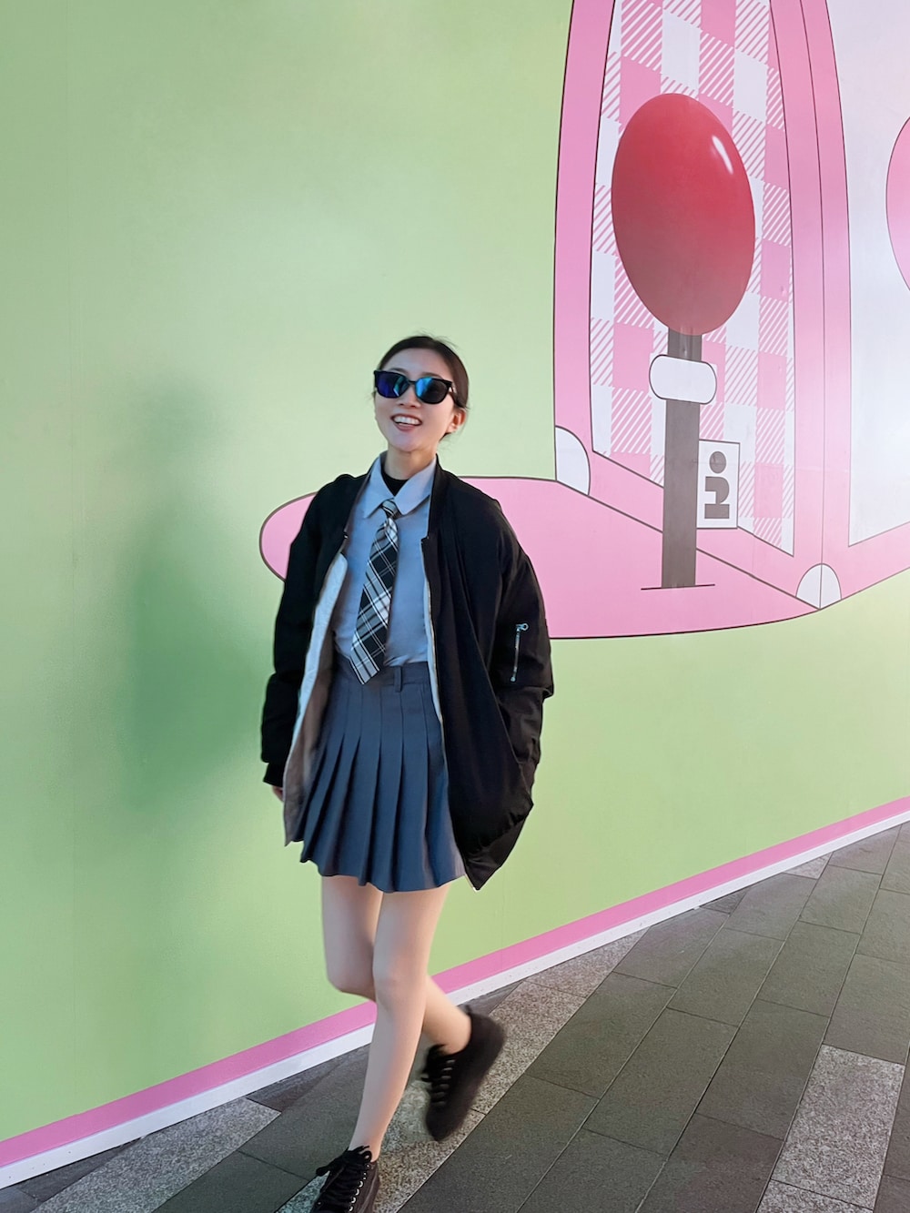 ブラック系のダウンジャケット/コート、グレー系のスカートを着用したレディースの春コーディネートの2枚目の写真