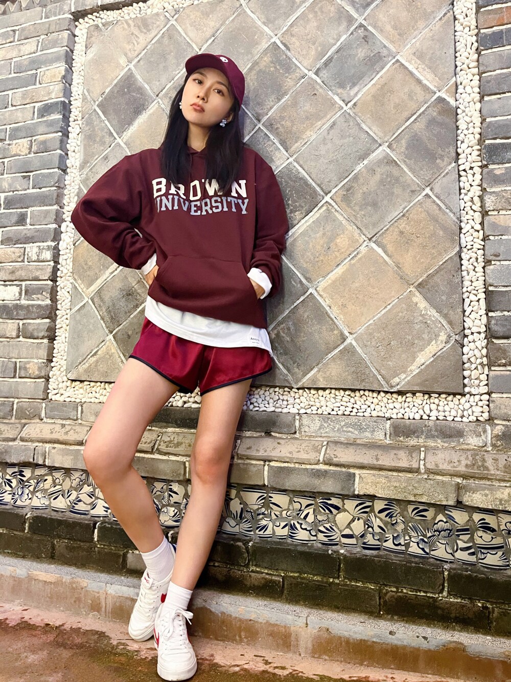 ブラウン系のパーカー、レッド系のカーゴパンツ、ホワイト系のスニーカーを着用したレディースの秋コーディネートの3枚目の写真