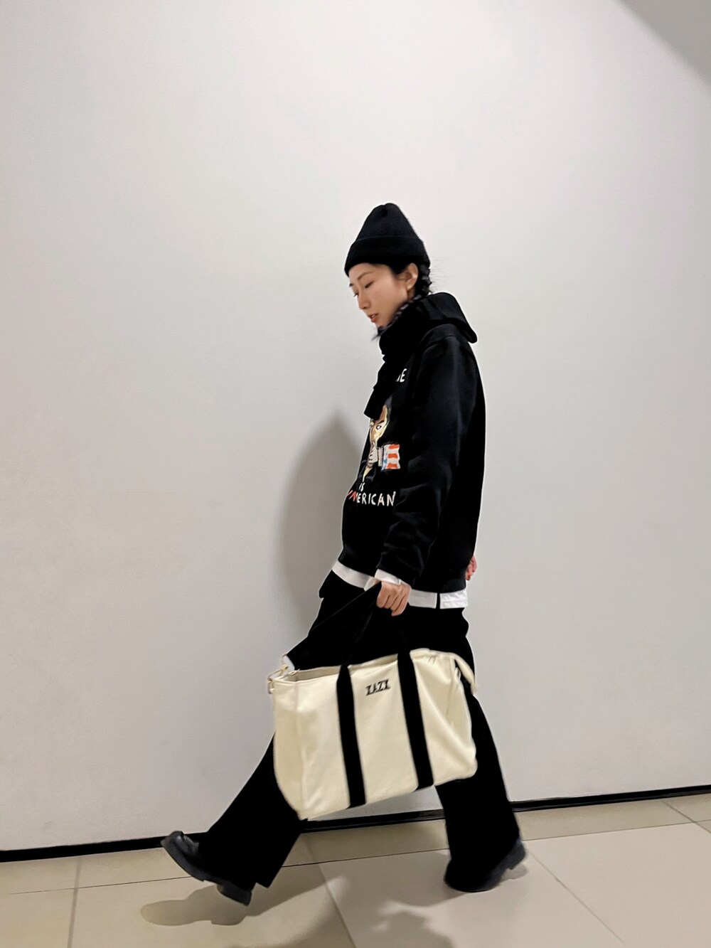 ブラック系のチノパンツを着用したレディースの春コーディネートの2枚目の写真