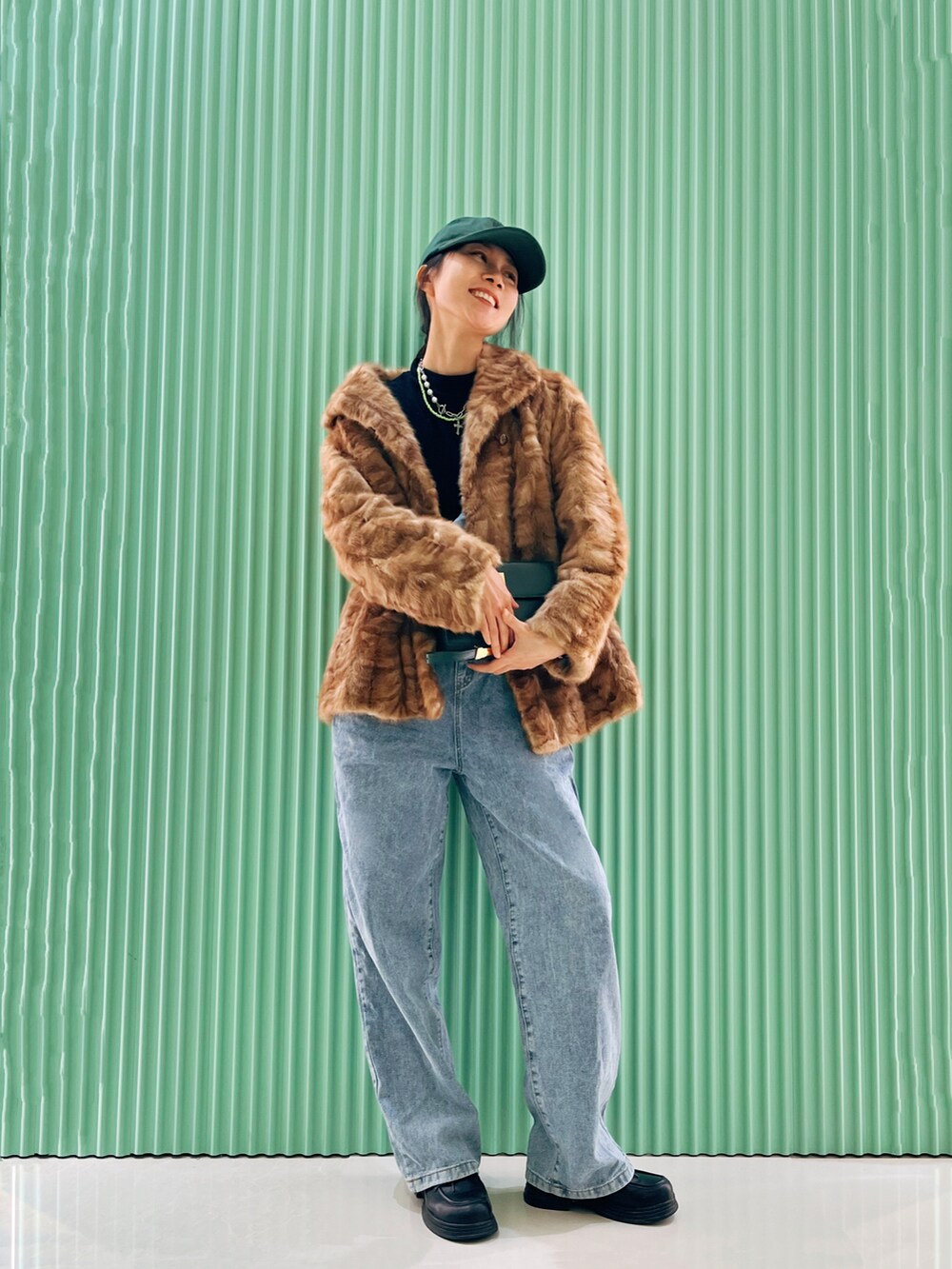 ゴールド系のその他アウター、ブルー系のデニムパンツを着用したレディースの冬コーディネートの2枚目の写真