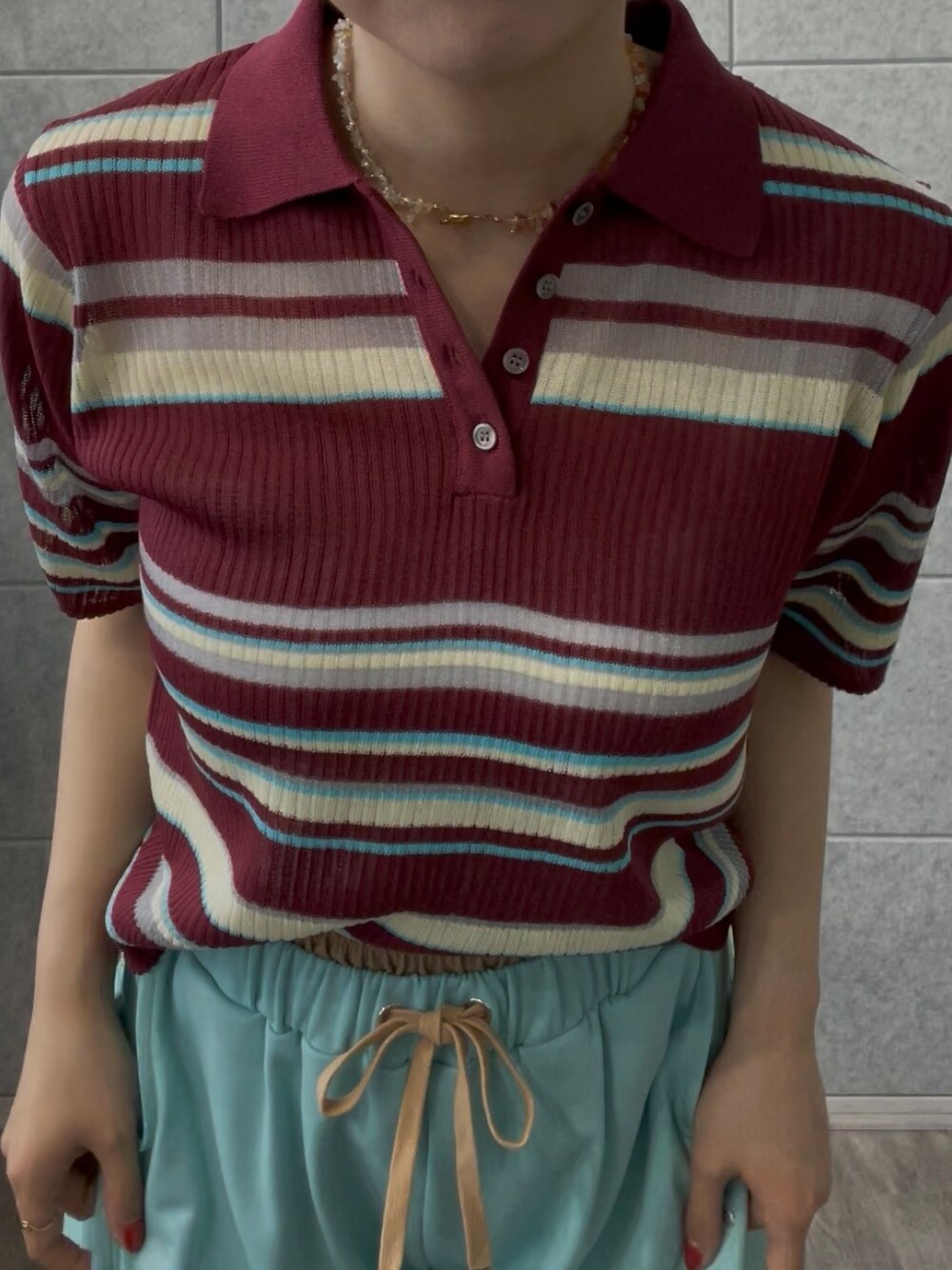 グリーン系のその他パンツ、レッド系のTシャツ/カットソーを着用したレディースの夏コーディネートの4枚目の写真