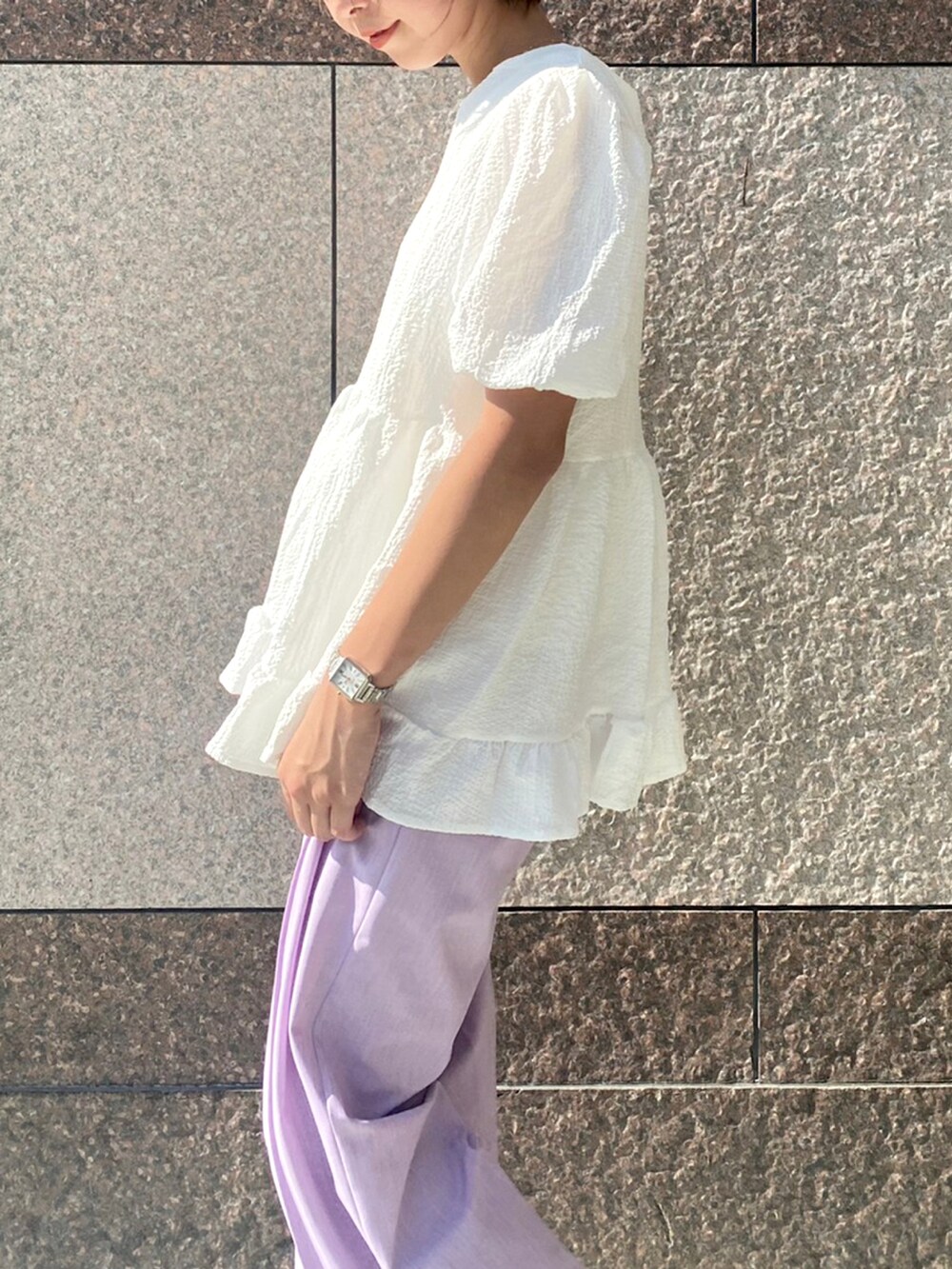 ピンク系のトップス、ブルー系のデニムパンツを着用したレディースの夏コーディネートの3枚目の写真