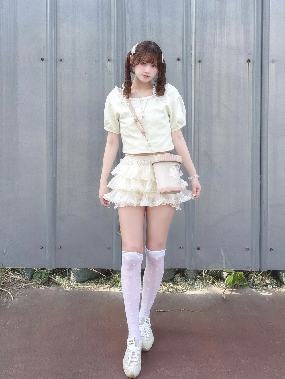グリーン系のTシャツ/カットソー、ホワイト系のスカート、ピンク系のショルダーバッグを着用したレディースの夏コーディネートの2枚目の写真