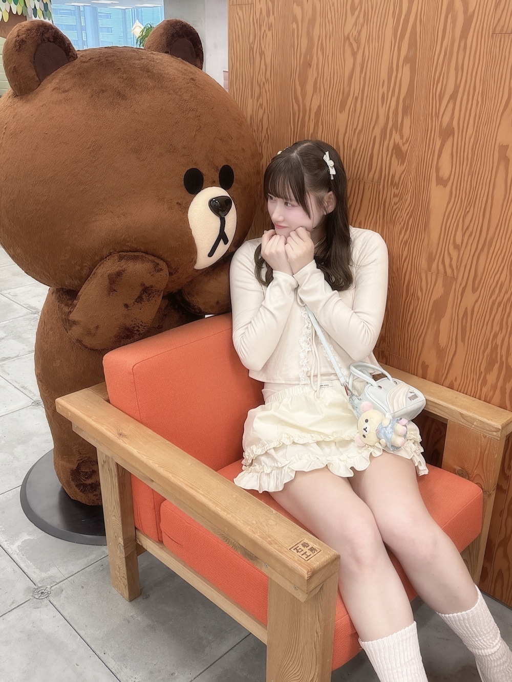 ホワイト系のデニムジャケット、ホワイト系のスカート、ホワイト系のスニーカーを着用したレディースの春コーディネートの2枚目の写真