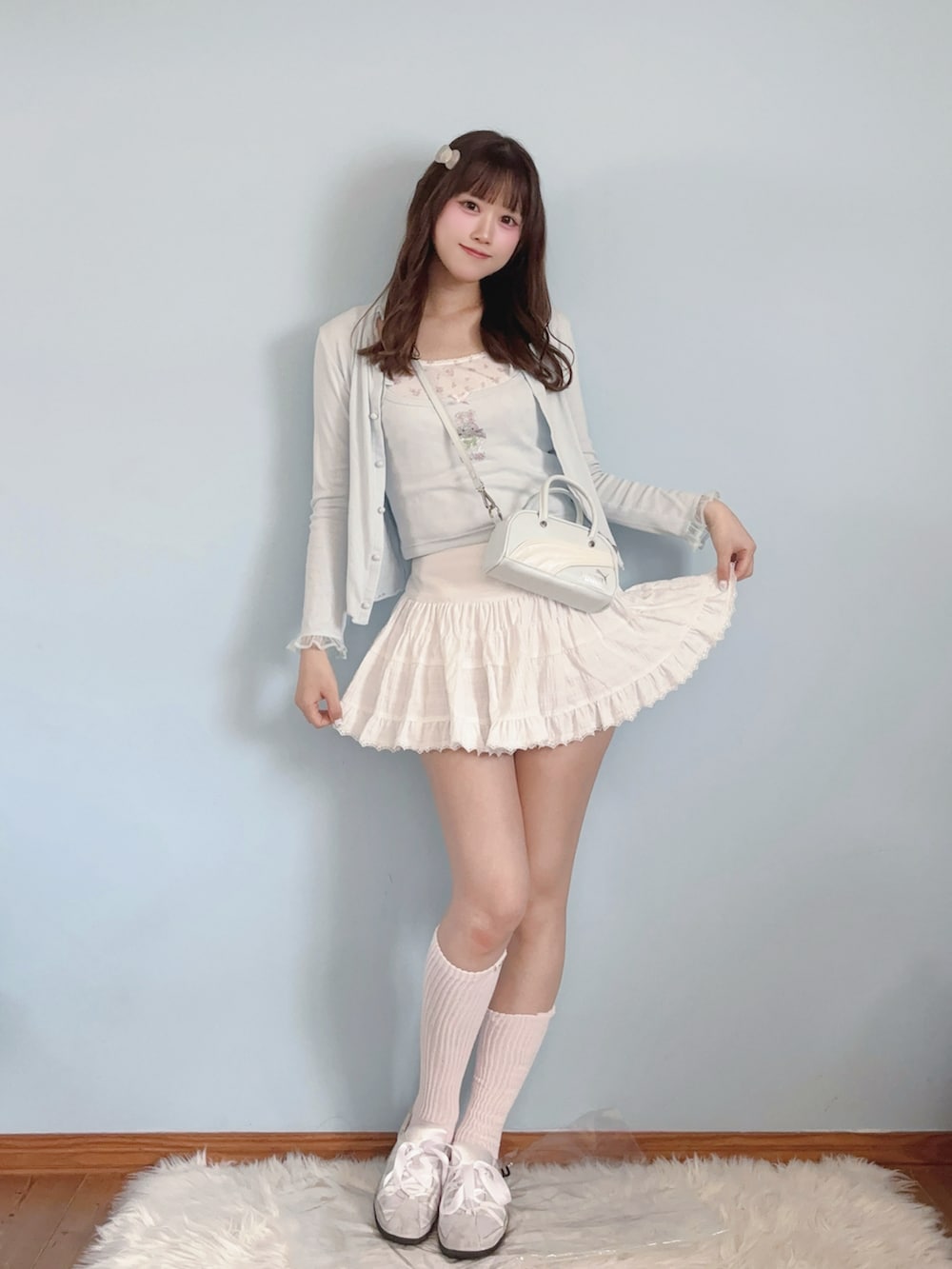 ブルー系のハンドバッグ、ホワイト系のスカート、ブルー系のキャミソールを着用したレディースの春コーディネートの4枚目の写真