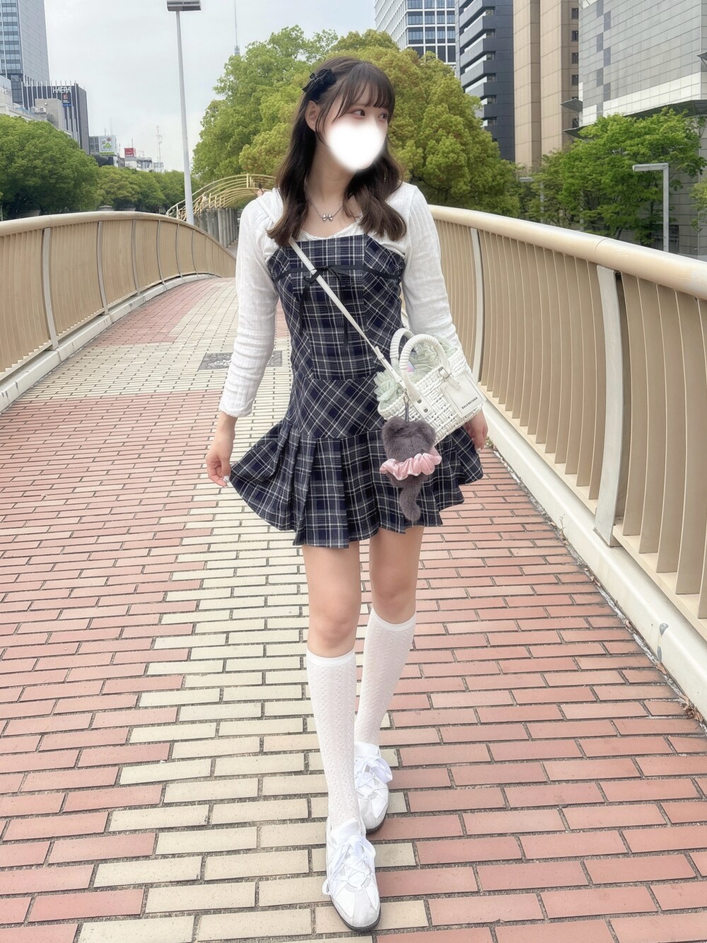 ブルー系のワンピース、ホワイト系のトップス、ホワイト系のショルダーバッグを着用したレディースの春コーディネートの2枚目の写真