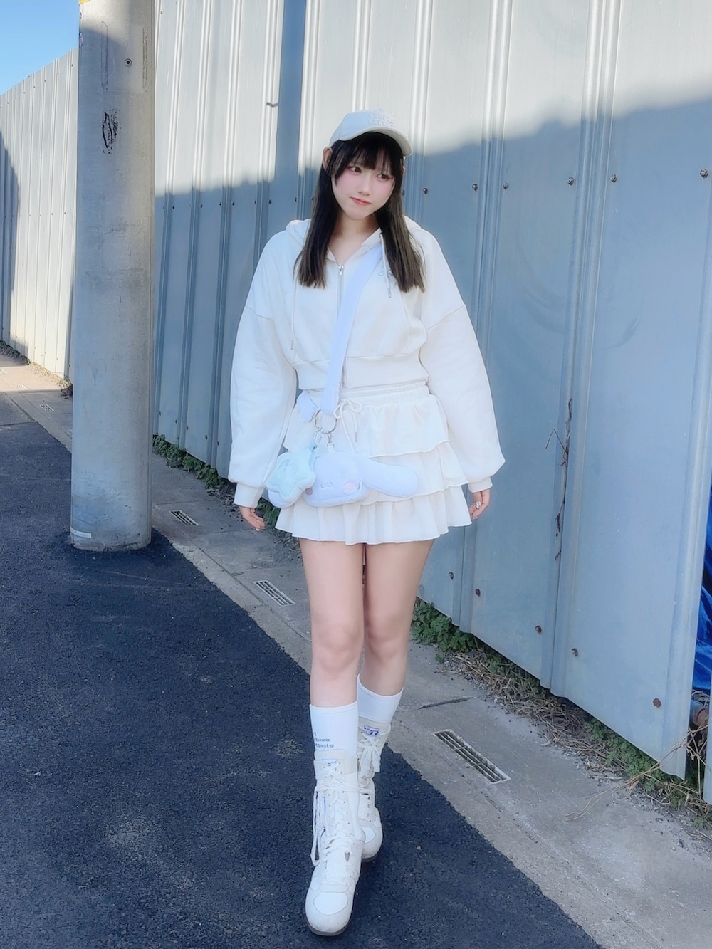 ホワイト系のトップス、ホワイト系のスカート、ホワイト系のブーツを着用したレディースの春コーディネートの2枚目の写真