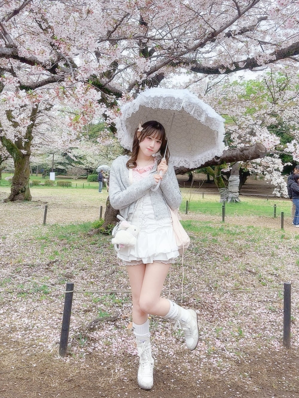 ホワイト系のトップス、ピンク系のTシャツ/カットソー、グレー系のカーディガン/ボレロを着用したレディースの春コーディネートの2枚目の写真