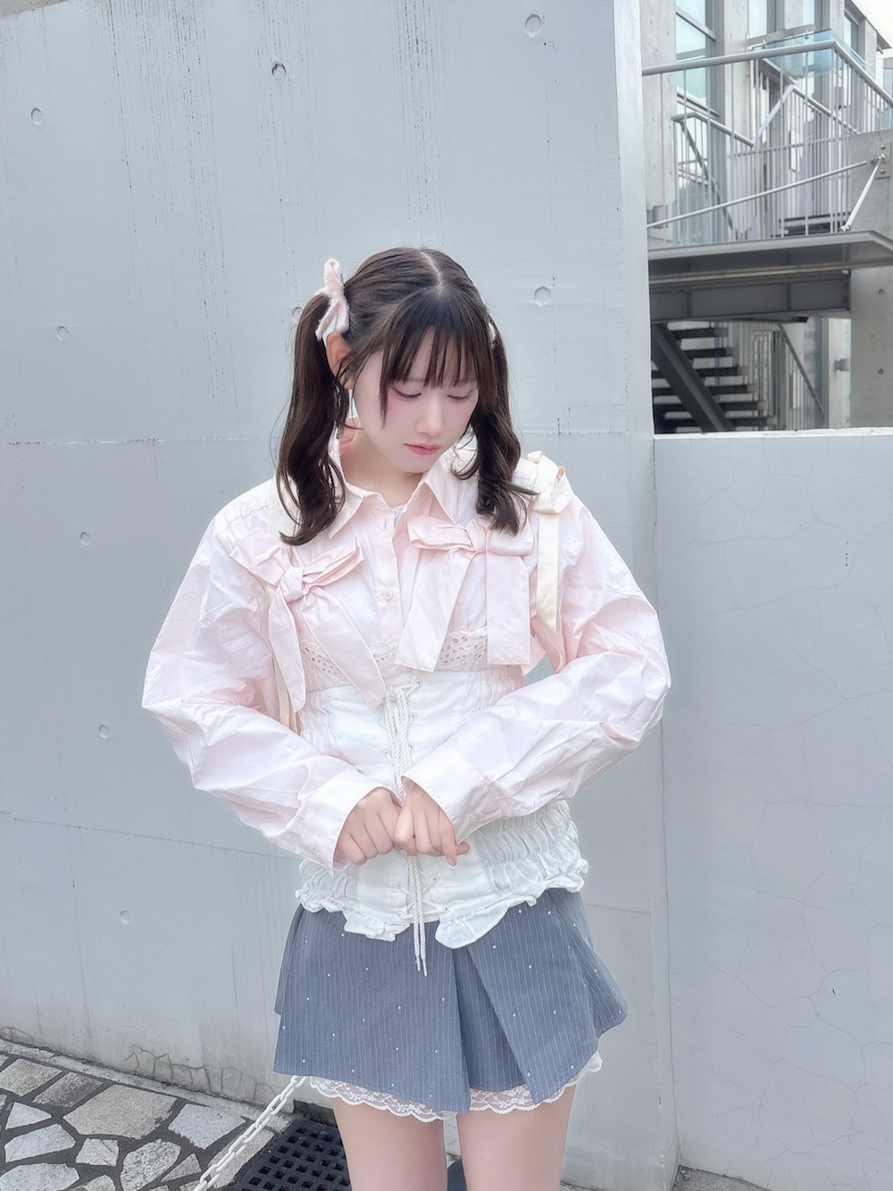 ピンク系のシャツ/ブラウス、グレー系のスカート、ホワイト系のその他トップスを着用したレディースの冬コーディネートの2枚目の写真