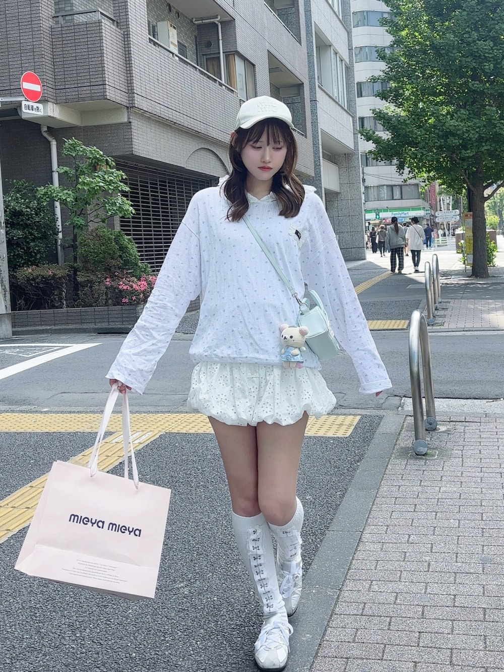 ホワイト系のTシャツ/カットソー、ブルー系のハンドバッグ、ホワイト系のパンツを着用したレディースの春コーディネートの4枚目の写真