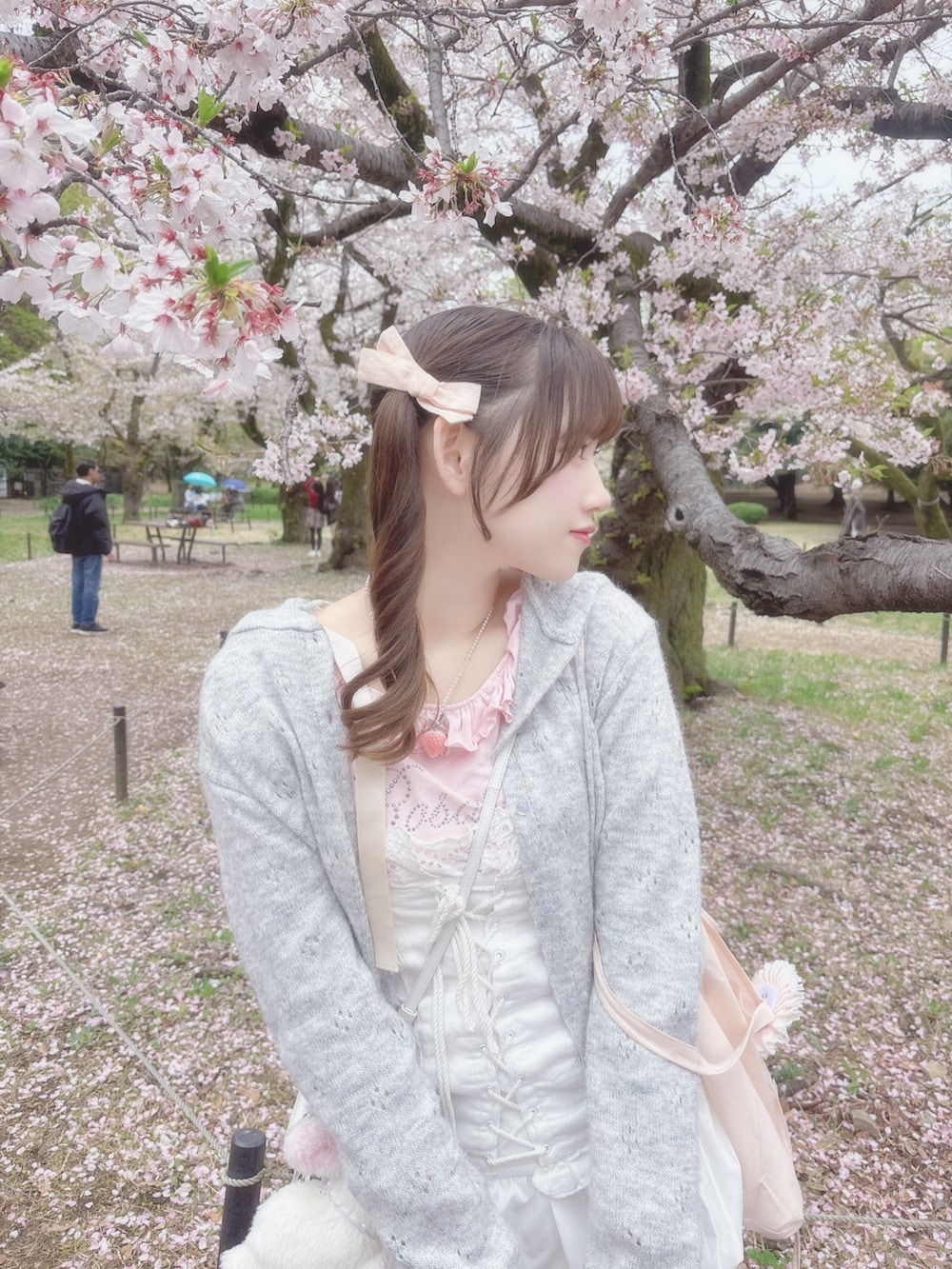 ホワイト系のトップス、ピンク系のTシャツ/カットソー、グレー系のカーディガン/ボレロを着用したレディースの春コーディネートの3枚目の写真