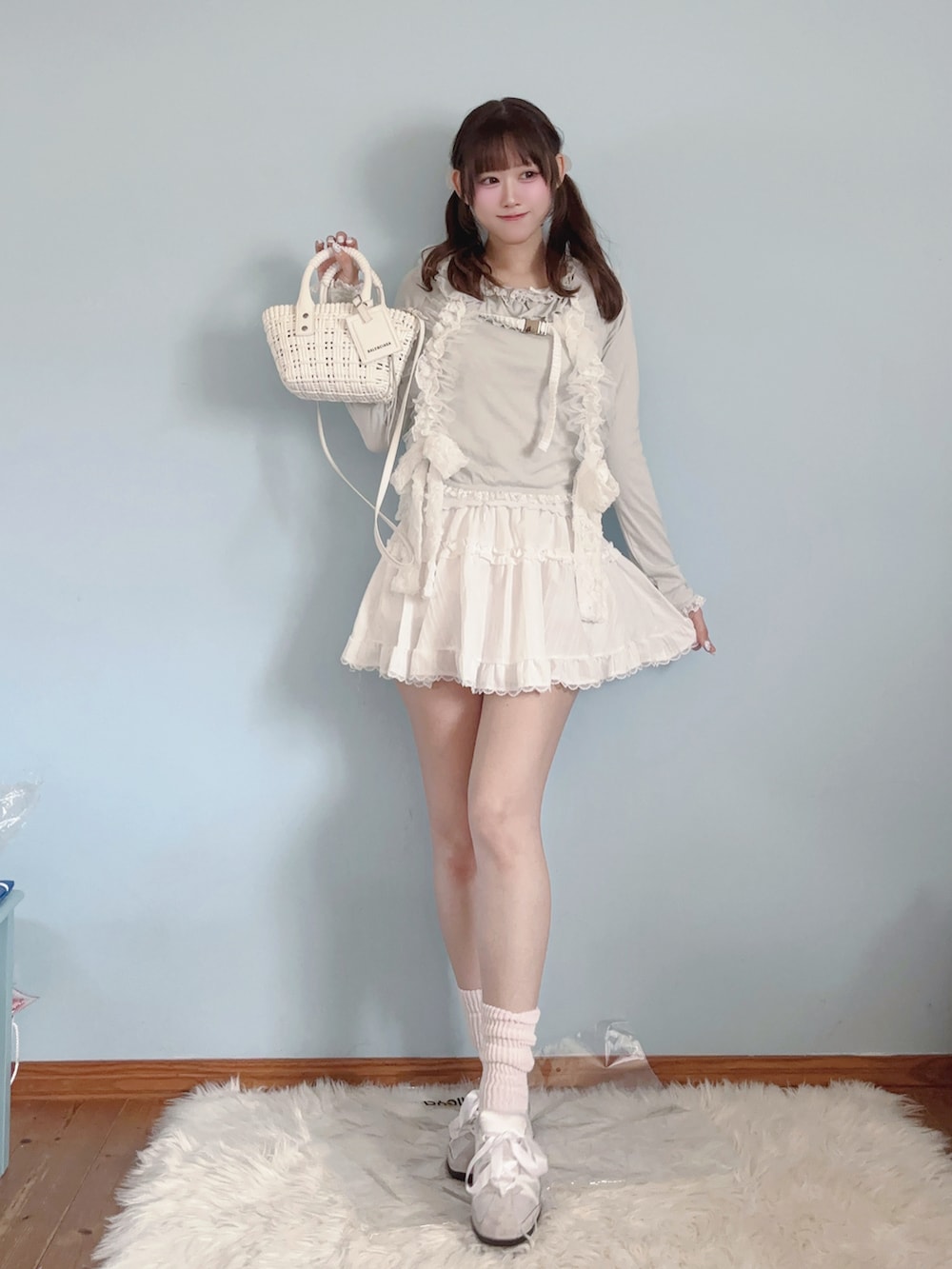グリーン系のTシャツ/カットソー、ホワイト系のスカート、ホワイト系のショルダーバッグを着用したレディースの春コーディネートの2枚目の写真