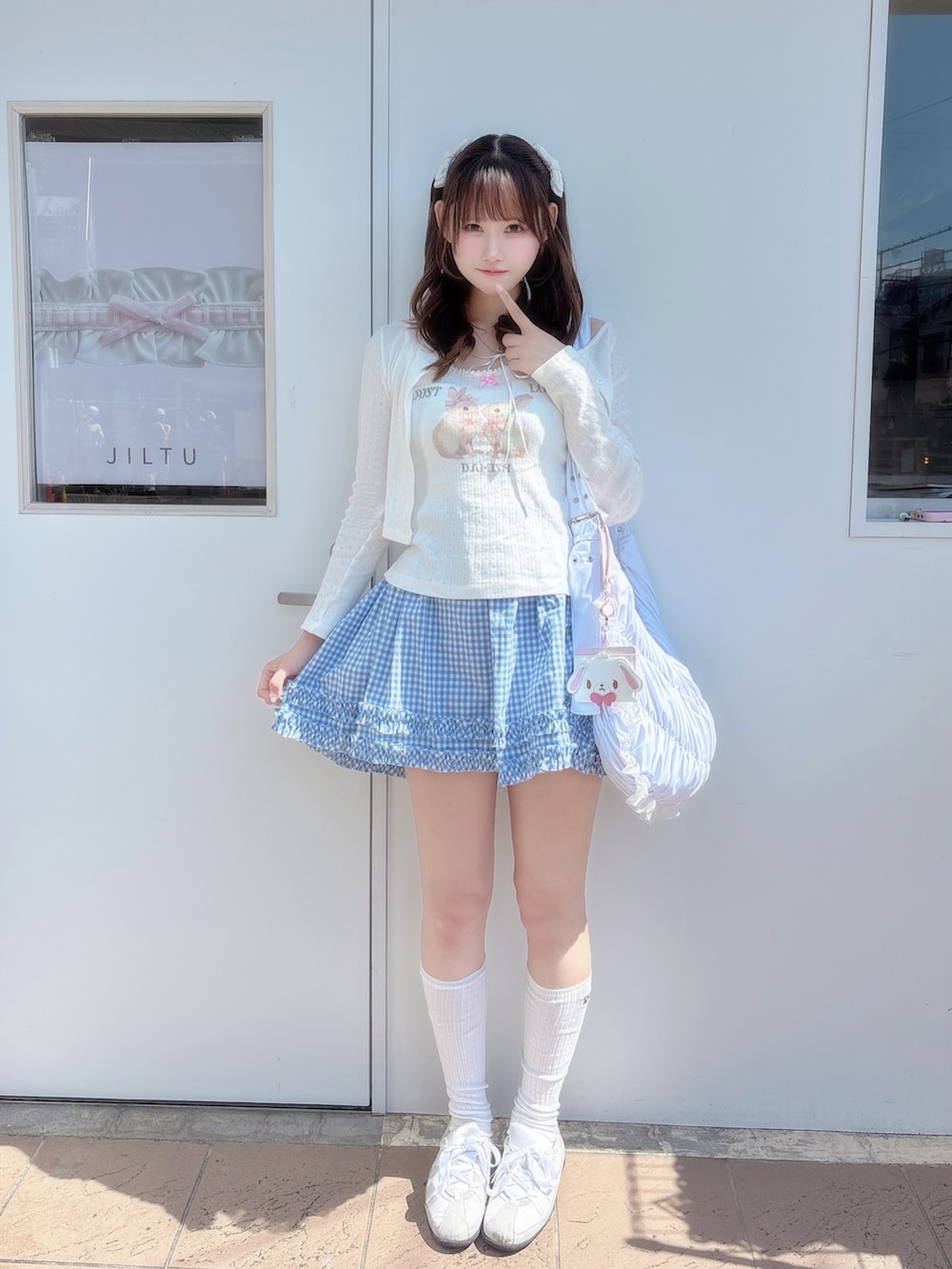 ホワイト系のタンクトップ、ホワイト系のカーディガン/ボレロ、ブルー系のスカートを着用したレディースの春コーディネートの2枚目の写真
