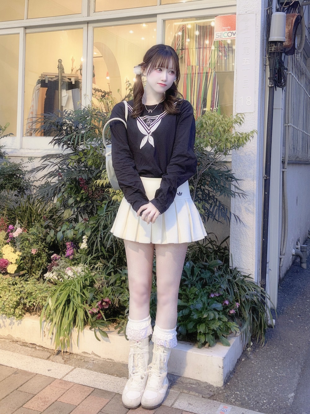 ホワイト系のスカート、ブラック系のトップス、ブルー系のバッグを着用したレディースの冬コーディネートの2枚目の写真